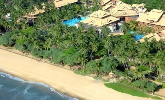 aerial view of a tropical beach resort with multiple buildings , palm trees , and a sandy beach at Royal Palms Beach Hotel