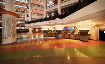 a large , well - lit atrium with a multi - colored floor and multiple levels of walkways leading to the entrance at Resorts World Kijal