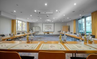 a conference room with a large table , chairs , and papers set up for a meeting at Akzent Hotel Aufkirchen