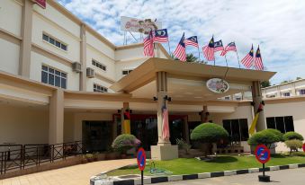 a large building with multiple flags and an american flag flying outside , creating a festive atmosphere at Garden View Hotel