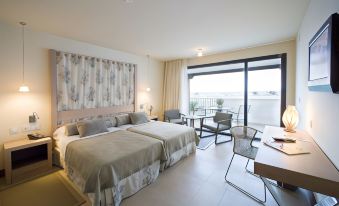 a hotel room with two beds , a balcony , and a dining table , all set up for a comfortable stay at Parador de Mojacar