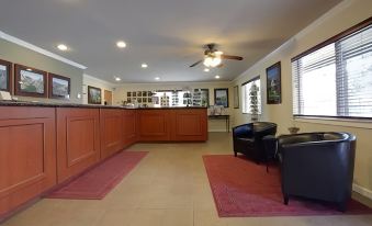 a hotel lobby with a check - in desk , couches , and chairs arranged for guests to check in at Yosemite Westgate Lodge