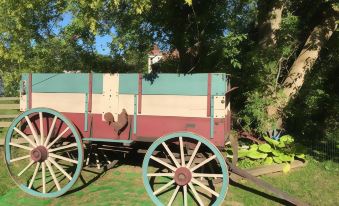 a red and white wagon with a rooster logo is parked in a grassy area at Dragonfly Bed and Breakfast
