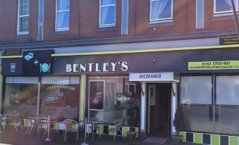 a brick building with a restaurant on the ground floor , which appears to be a coffee shop at Bentleys