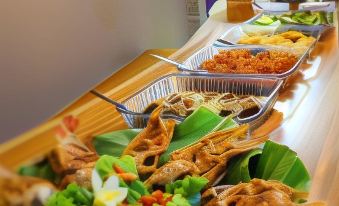 a buffet table filled with a variety of dishes , including meat , vegetables , and other food items at Van House