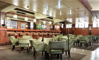 a large , empty bar with several chairs and tables set up for patrons to sit and enjoy their drinks at Hotel Imperial