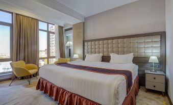 a large bed with a white headboard and red accent is in a hotel room at Hotel Lulu