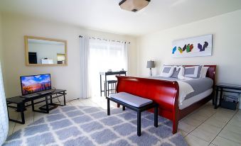 a modern bedroom with a large bed , red headboard , and a flat - screen tv mounted on the wall at Seven Arches