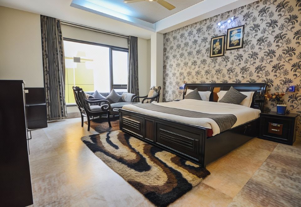 a modern bedroom with a large bed , two chairs , and a rug on the floor at The Grand Hotel