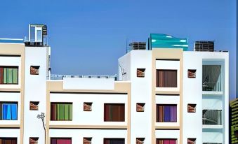 a white building with colorful windows and a blue roof , under a clear blue sky at Hotel 8th Planet