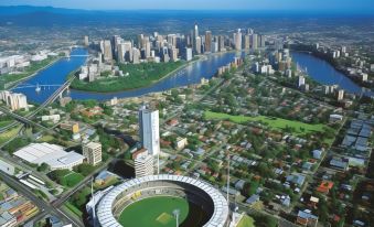 a bird 's eye view of a city with a large stadium in the center and skyscrapers surrounding it at Ibis Budget Windsor Brisbane