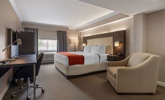 a modern hotel room with a large bed , desk , and chair , as well as a desk area with a computer at Westminster Hotel