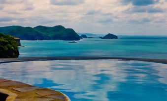 a large body of water , possibly an ocean or a lake , with a stone pier extending into the water at Aqua Nicaragua