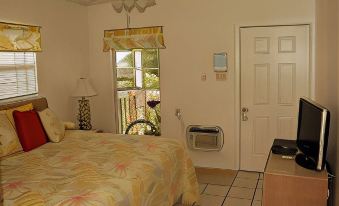 a bedroom with a bed , a microwave , and a door leading to a balcony at Paradise Villas