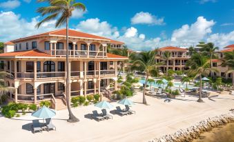 a beachfront resort with multiple buildings , umbrellas , and lounge chairs under a blue sky at Coco Beach Resort