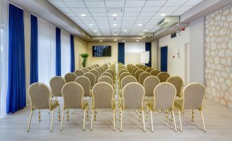 a large conference room with rows of chairs arranged in a semicircle , ready for an event at Hotel Pinija