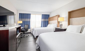 a hotel room with two beds , a desk , and a chair , all neatly arranged in a modern style at Holiday Inn Weirton - Steubenville Area
