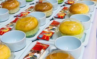 a long table filled with a variety of pastries and desserts , including cakes , donuts , and other treats at Tokyo Hotel