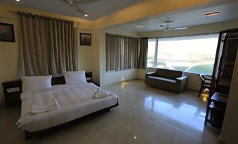 a modern bedroom with a large bed , couch , and windows , giving it a bright and airy atmosphere at Sadas River Rock Resort