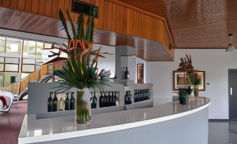 a white reception desk with a vase of flowers and a vase of flowers on it at Lyndoch Hill