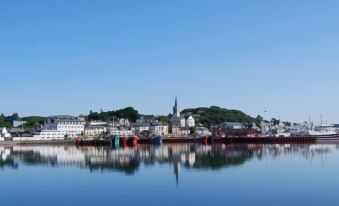 a picturesque town with a church and boats in the water , reflecting the clear blue sky at Bay View Hotel
