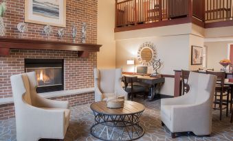 a cozy living room with a fireplace , a fireplace fan , and a fireplace mantle at AmericInn by Wyndham Mounds View Minneapolis