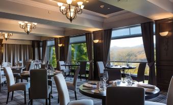 a large dining room with multiple tables and chairs , some of which are occupied by people at Beech Hill Hotel & Spa