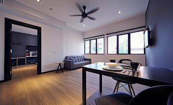 a modern living room with hardwood floors , a dining area , and a kitchen in the background at Arena Boutique Hotel Kuala Terengganu