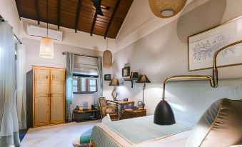 a cozy bedroom with wooden ceiling , white walls , and blue bedspread , along with various furniture and decorations at Eraeliya Villas & Gardens