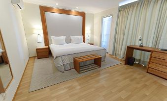 a large bed with a wooden headboard and footboard is in a room with hardwood floors at Lagoa Hotel