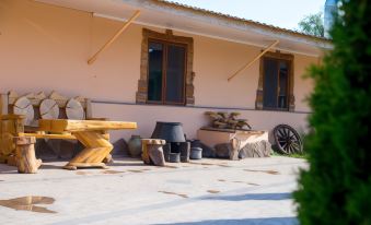 a wooden table and chairs are placed in front of a house with stone pillars at Richmind Hotel
