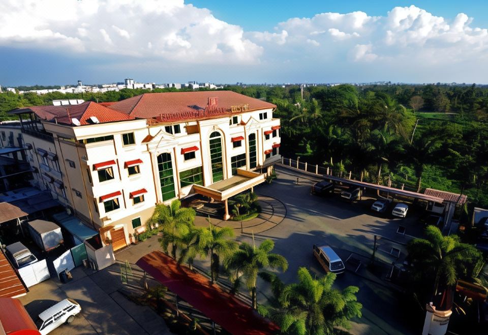 a large building with a red roof and white walls is surrounded by palm trees and cars at Grand Palace Hotel