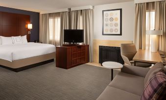 a hotel room with a bed , couch , and tv . also a fireplace in the room at Sonesta ES Suites Nashville Brentwood
