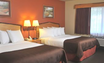 a hotel room with two beds , one on the left and one on the right side of the room at AmericInn by Wyndham Oswego
