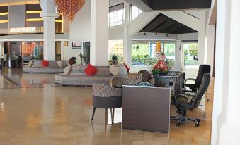 a hotel lobby with a reception desk , chairs , and a red chandelier hanging from the ceiling at Thistle Port Dickson Resort