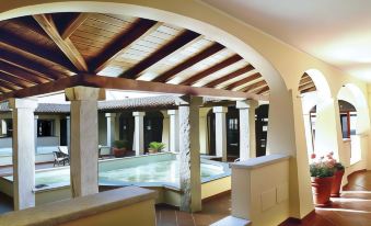 a large indoor swimming pool surrounded by a wooden deck , with several people enjoying their time in the pool at Volcano House