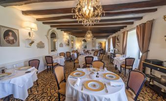 a large dining room with white tables and chairs , gold place settings , and a chandelier hanging from the ceiling at Hotel Saint-Martin - Younan Collection
