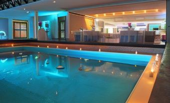 a large swimming pool with blue lights reflecting off the water , creating a relaxing atmosphere at El Paseo