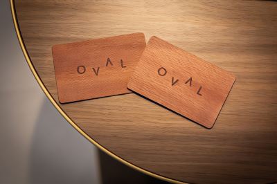 "two wooden business cards with the word "" oval "" on them are placed on a wooden table" at Oval Hotel at Adelaide Oval, an EVT hotel