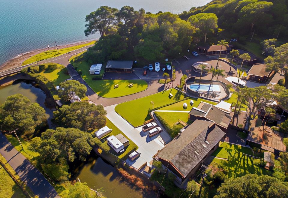 an aerial view of a resort with multiple buildings , a pool , and a beach in the background at Anglers Lodge