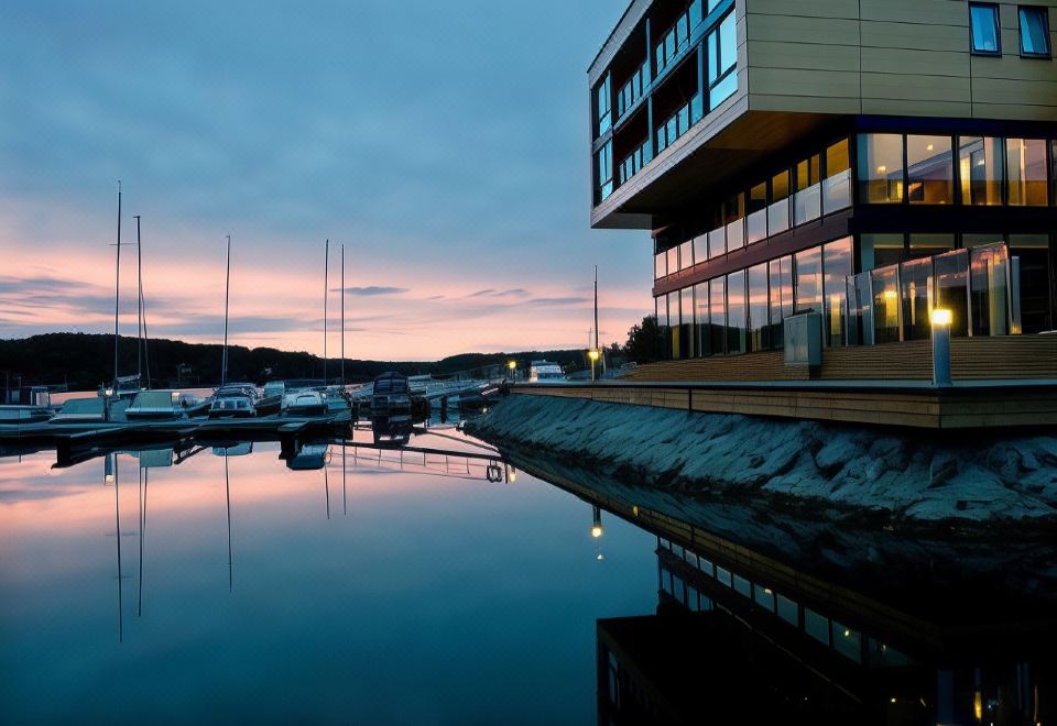 a building with a parking lot in front of it , reflecting in the water at sunset at Son Spa, an Ascend Member