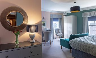 a modern bedroom with a large bed , a dresser , and a mirror on the wall at The Celtic Royal Hotel