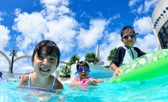 a group of children , including a boy and two girls , are swimming in a pool together at Loisir Hotel Naha