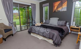 a spacious bedroom with a large bed , a window , and a painting on the wall at The Summit Lodge