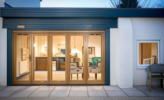 a modern house with large glass doors that open onto a patio , providing a view of the outdoors at Helen Browning's Royal Oak