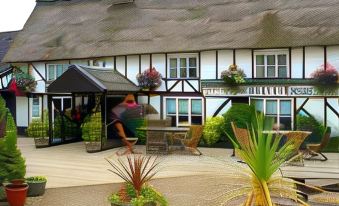 a woman is standing outside a building , wearing a hat and posing for a picture at The Willow House