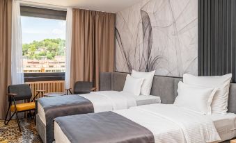 a modern hotel room with two beds , a couch , and large windows overlooking the city at Hotel Holiday