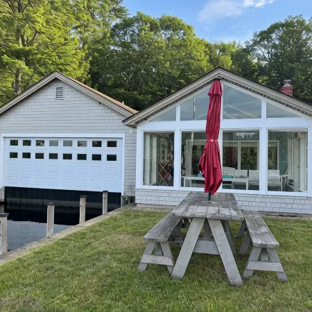 Stunning lakefront home with a boathouse, private dock, firepit and lake views