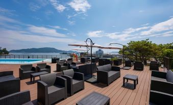 a rooftop patio with several couches and chairs arranged in a comfortable seating area , overlooking the ocean at Todaya