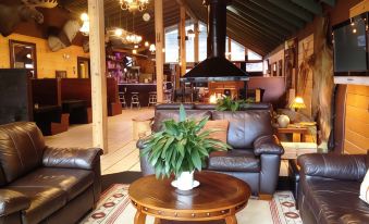 a cozy living room with several leather couches and chairs arranged around a coffee table at Shasta Inn
